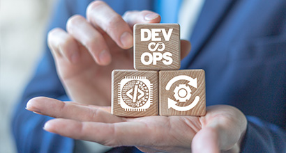 Devops agile Software Development Operations Konzept auf Holzwürfeln in Händen eines Geschäftsmannes